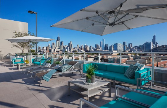 Colorful, bright fabrics, throw pillows, and umbrellas add fresh appeal to outdoor common areas such as this rooftop deck.