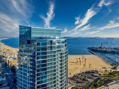 Shoreline Gateway in Long Beach, California, takes cues from the ocean with sail iconography along the south elevation and the sweeping glass curvature of the building offering ocean views from almost every unit.