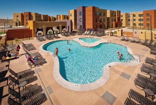WIDE APPEAL: Upperclassmen living at Lobo Village can have fun at a resort-style swimming pool and hot tub, sand volleyball court, landscaped seating, barbecue pavilion, and wider sidewalks than usual so several students can stroll together. To fit the Southwestern locale, the buildings were sheathed in pueblo-style stucco with a nod toward playful modern design and pops of bright purple and orange.