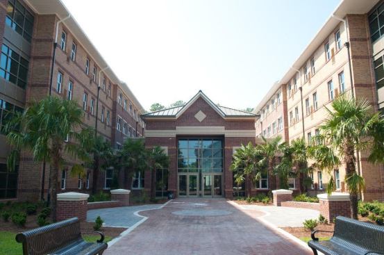 This four-story dorm opened in August 2010 as a residence hall for freshmen students at Armstrong Atlantic State University. Each suite contains two private bedrooms and one bathroom. There are common areas on each floor for studying and socializing. A game room on the first floor doubles as a media room with black-out shades and a high-tech audio/visual system. The lobby is clean and spacious, with a high vaulted ceiling that extends toward the game room, separated from the lobby by tall windows with inlaid artwork of falling leaves. Located just a short walk from the campus’ main quad, students living in Windward Commons will find comfortable living in a convenient location.