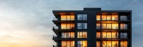 Modern apartment building at sunset, glowing windows